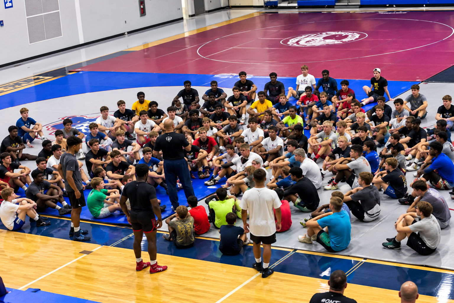 Wrestling team gathered on mat — group performance coaching session